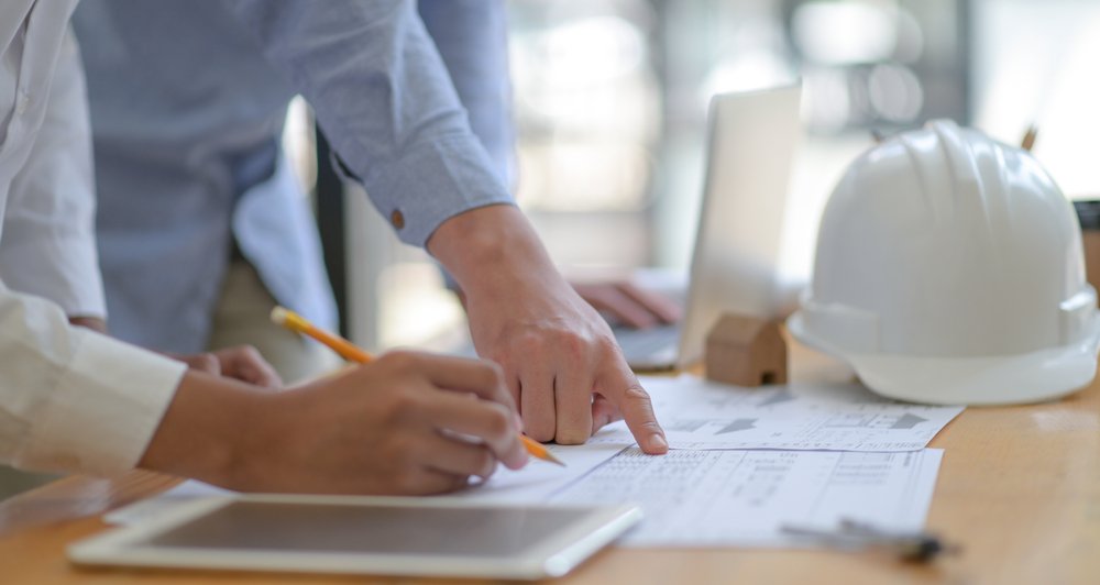 Contractors doing some paperwork on the desk.