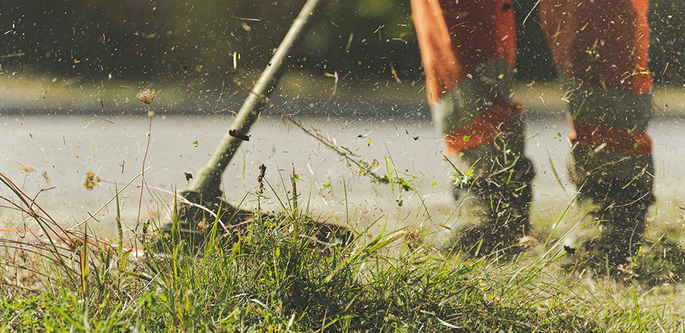worker cutting grasses from edger.