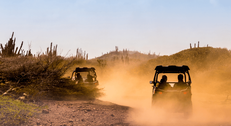people are driving off rode and dust wave coming