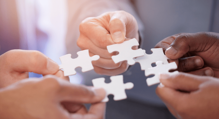 people holding puzzles pieces in there hands