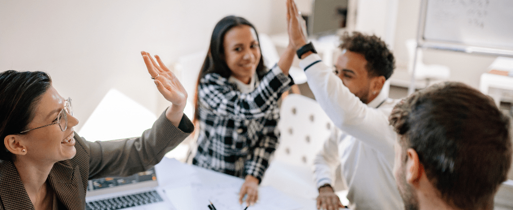 Team mates are giving high five within each other in the office