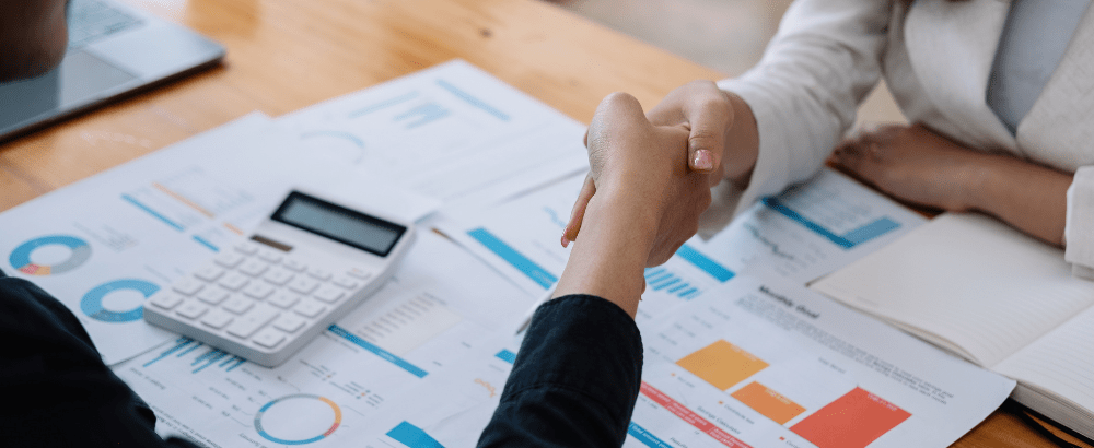 client and the executive are shaking hands sitting on the table